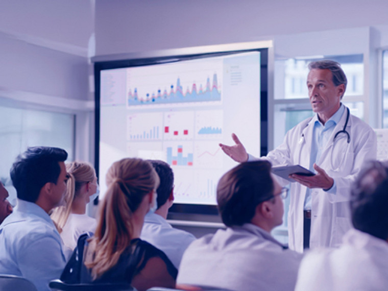 A medical professional delivering a lecture in a classroom.