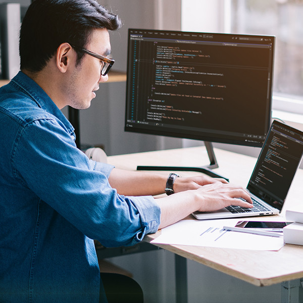 A man engaged in coding and software testing.