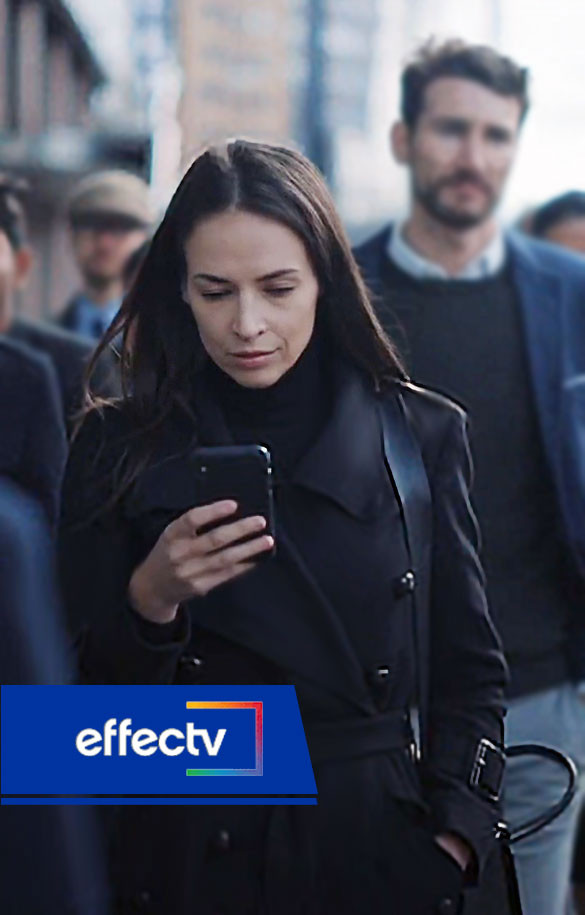 Woman walking in crowd looking at cellphone