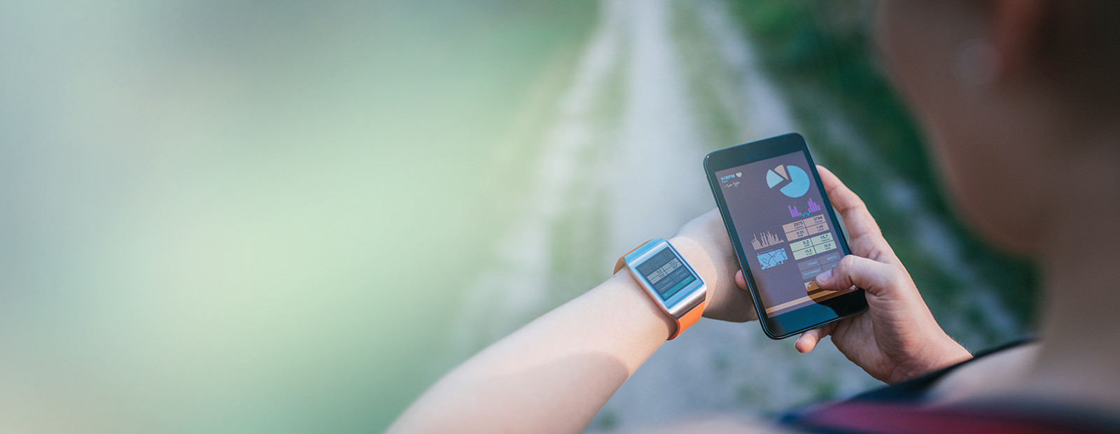 person looking at smartwatch and phone