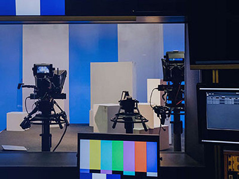 A monitor displaying vertical rainbow stipes, setup in studio