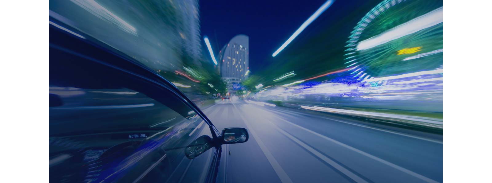 A fast-moving car on the road at night.