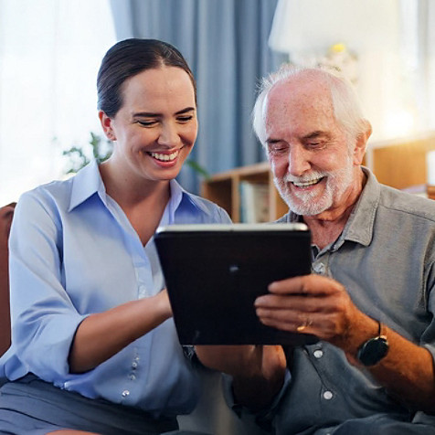 A woman helping an elderly person in accessing health information on a tablet