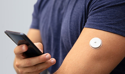 man holding phone and having some device on arm