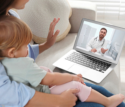 A mother and child meeting with a care provider via video conference