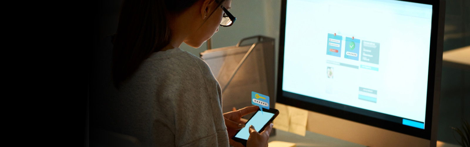 Woman checking her phone in front of her laptop screen