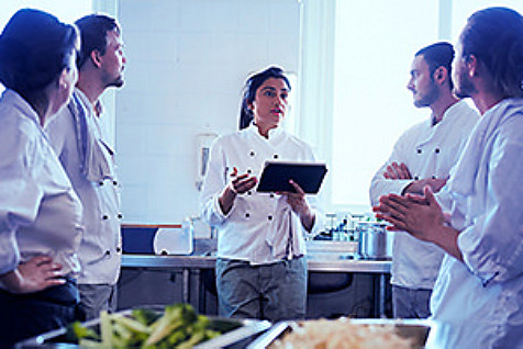 Chefs having group discussion with tablet