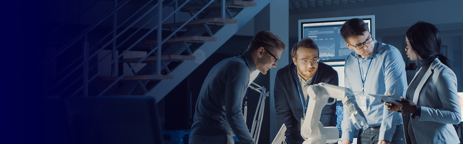 A diverse group of individuals gathered around a computer, engaged in discussion and collaboration