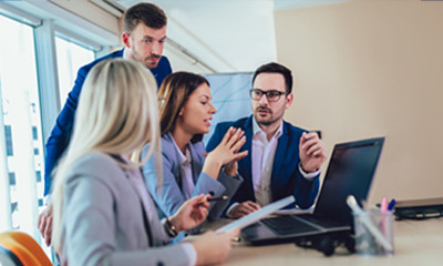 Vier Bürokollegen diskutieren etwas