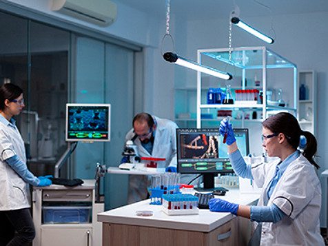 Three medical professionals working in a lab