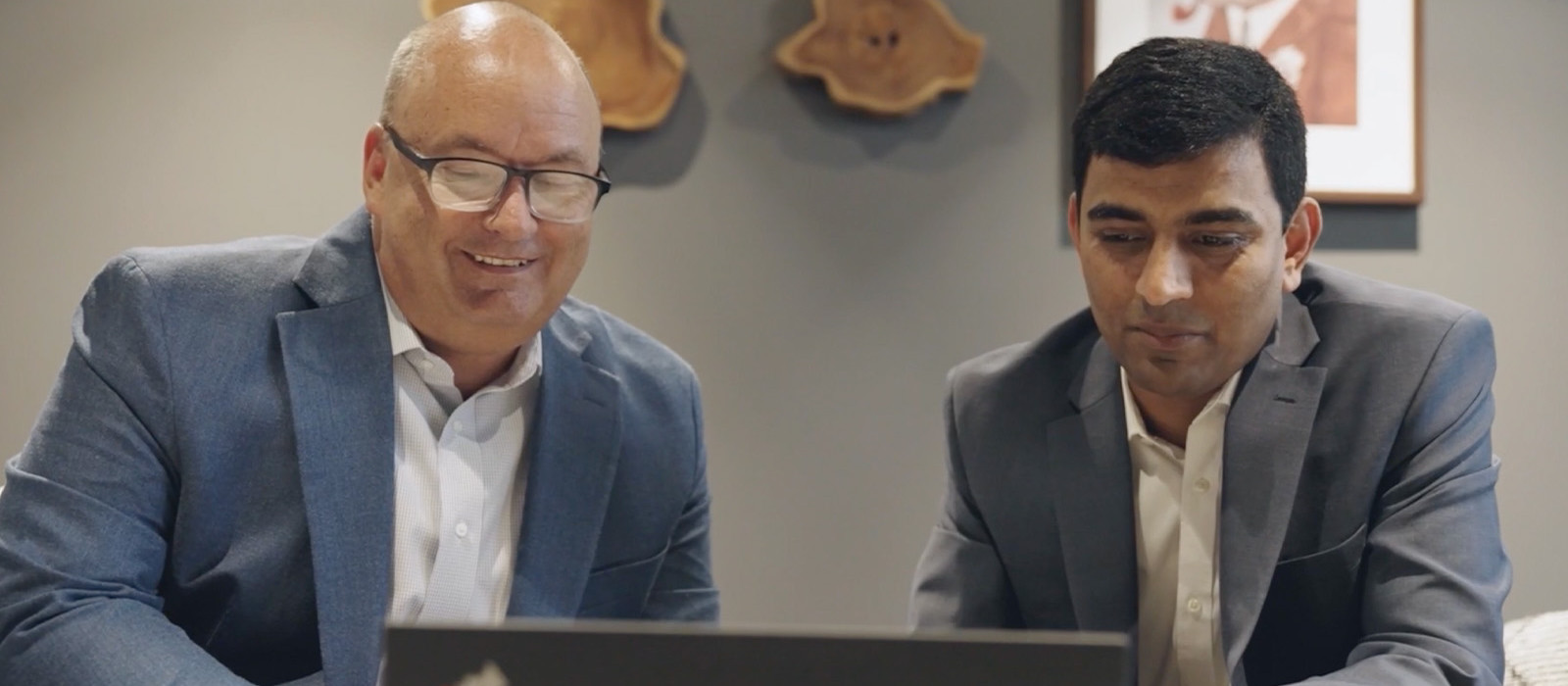 Two professionals looking into a laptop screen