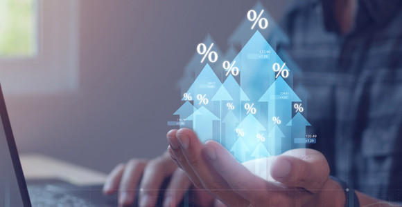 Mano sosteniendo flechas digitales que muestran los iconos de porcentaje ascendente