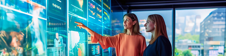 two female colleagues having a discussion and pointing at screen