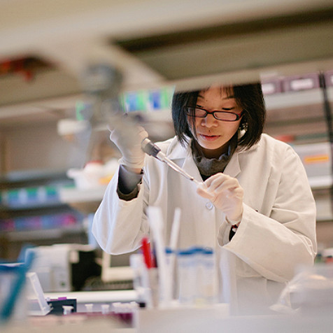Scientist performing laboratory research using a pipette in a clinical testing facility