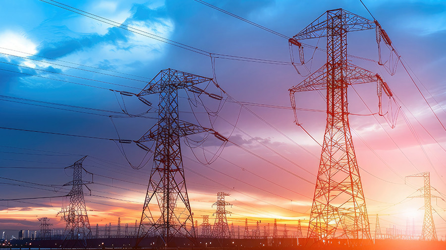 Electricity transmission towers and power lines at sunset.