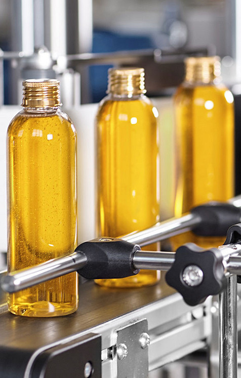 3 yellow bottles on a conveyor belt