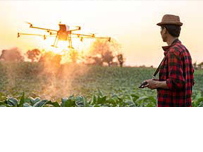 A man flying his drone over an agricultural field