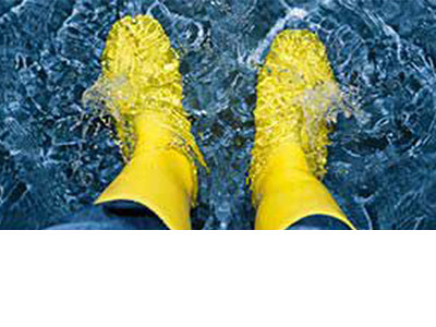 A pair of water-proof industrial boots partially dipped in clear water