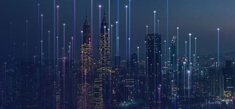 Vogelperspektive auf die Stadt mit hohen Gebäuden und Lichtern bei Nacht