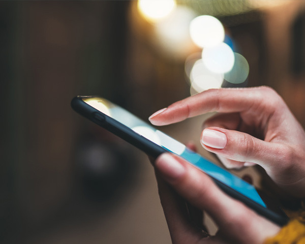 Closeup view of a hand holding a mobile phone and browsing.
