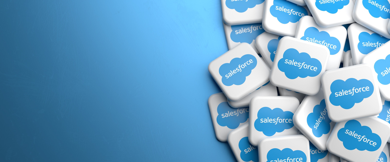 Logos of the company salesforce which offers cloud based solutions for Customer Relationship Management on a heap on a table. Copy space. Web banner format.