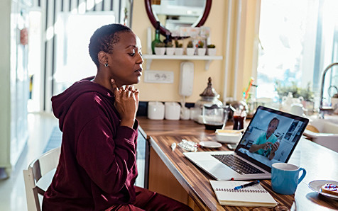 A woman attentively viewing a presentation on the laptop