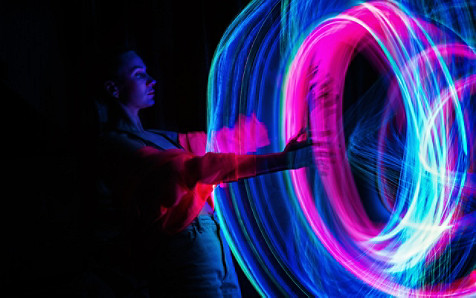 A girl standing in front of a round light trail
