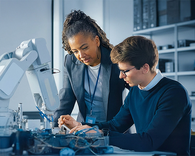 Two professionals assembling and calibrating a robotic system.