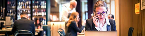 A woman talking on her mobile infront of a laptop