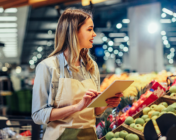 A woman holding a tablet and examining the items available.