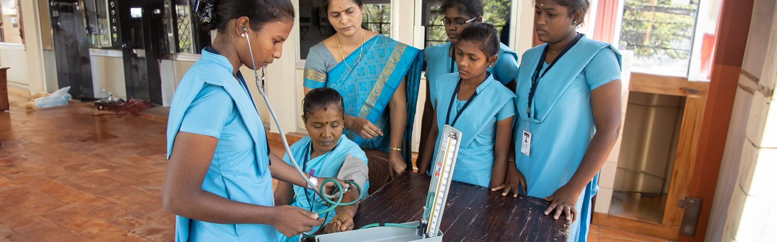 A nurse is getting trained to check blood pressure