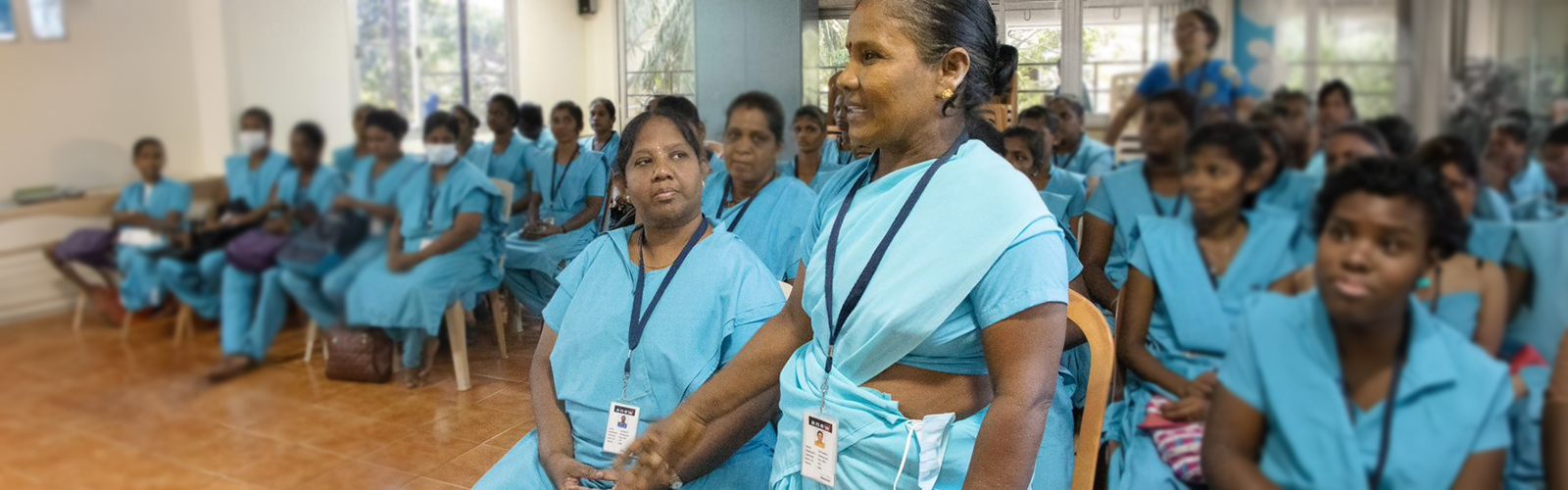 A nurse standing and the rest of the nurses are sitting in a class