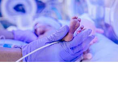 A examination gloves worn hand treating a newborn baby