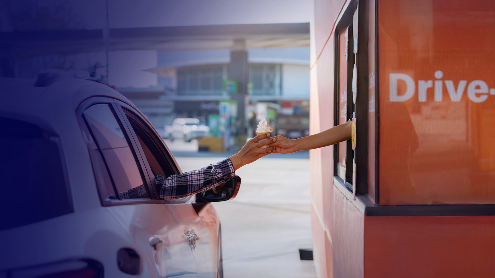 Car receiving ice cream at a drive-thru window.