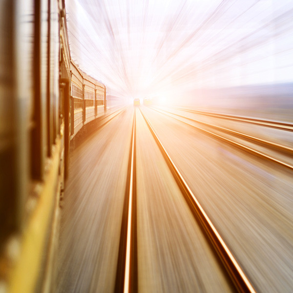 A train on the extreme left and a couple of railway tracks on the right of the frame