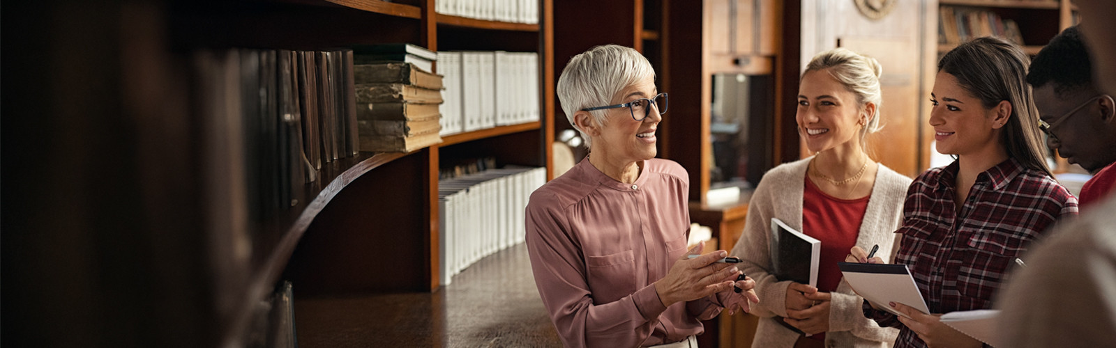 An elderly instructor having a conversation with young adults educators.
