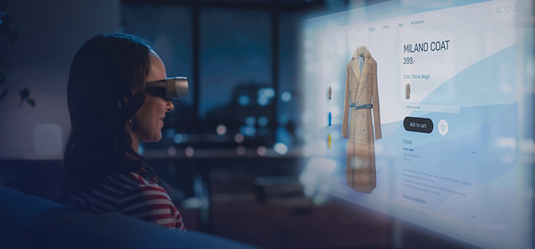 一位女士使用虚拟现实设备浏览米兰大衣网站。