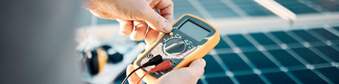 Hands holding a multimeter