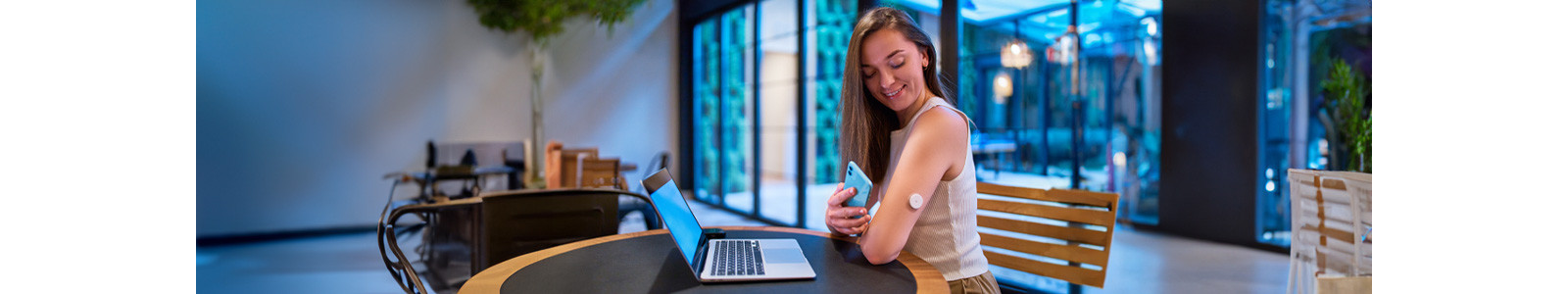 A woman scanning health and fitness device through her mobile attached to her hand