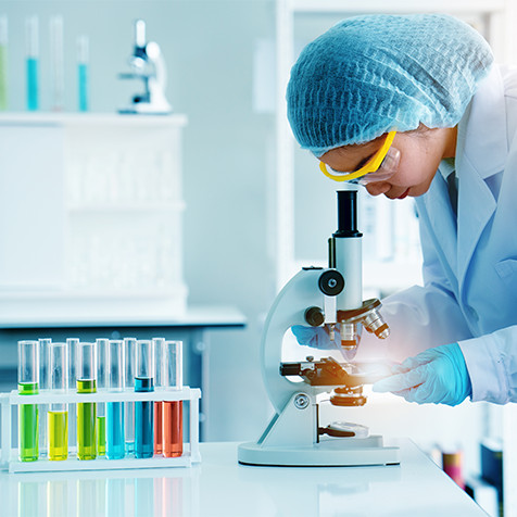 Frau, die durch das Mikroskop schaut