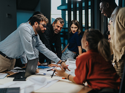 Un grupo de personas alrededor de un escritorio, haciendo un brainstorming