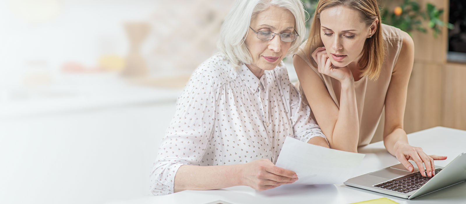 Mor och dotter diskuterar och tittar på en blankett för skadeanmälan