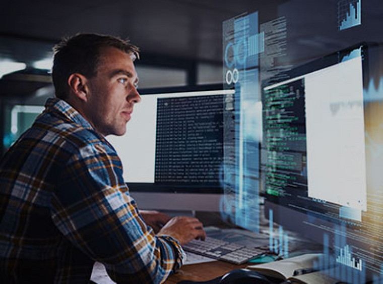 Man working on two monitors