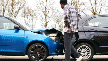 someone looking at a damaged car