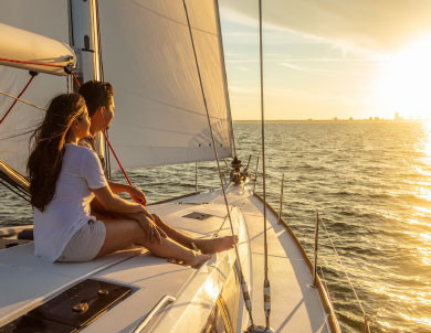 Couple assis sur un bateau et regardant le coucher du soleil