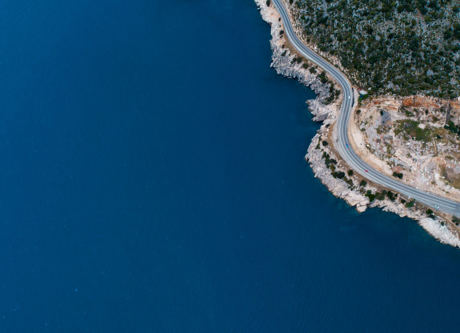 Aerial view of a body of water and a coastline highway.