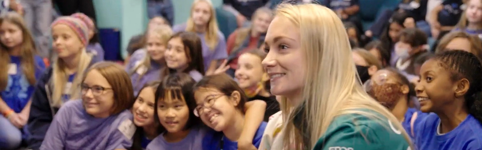 Jessica Hawkins rodeada de niñas en una escuela