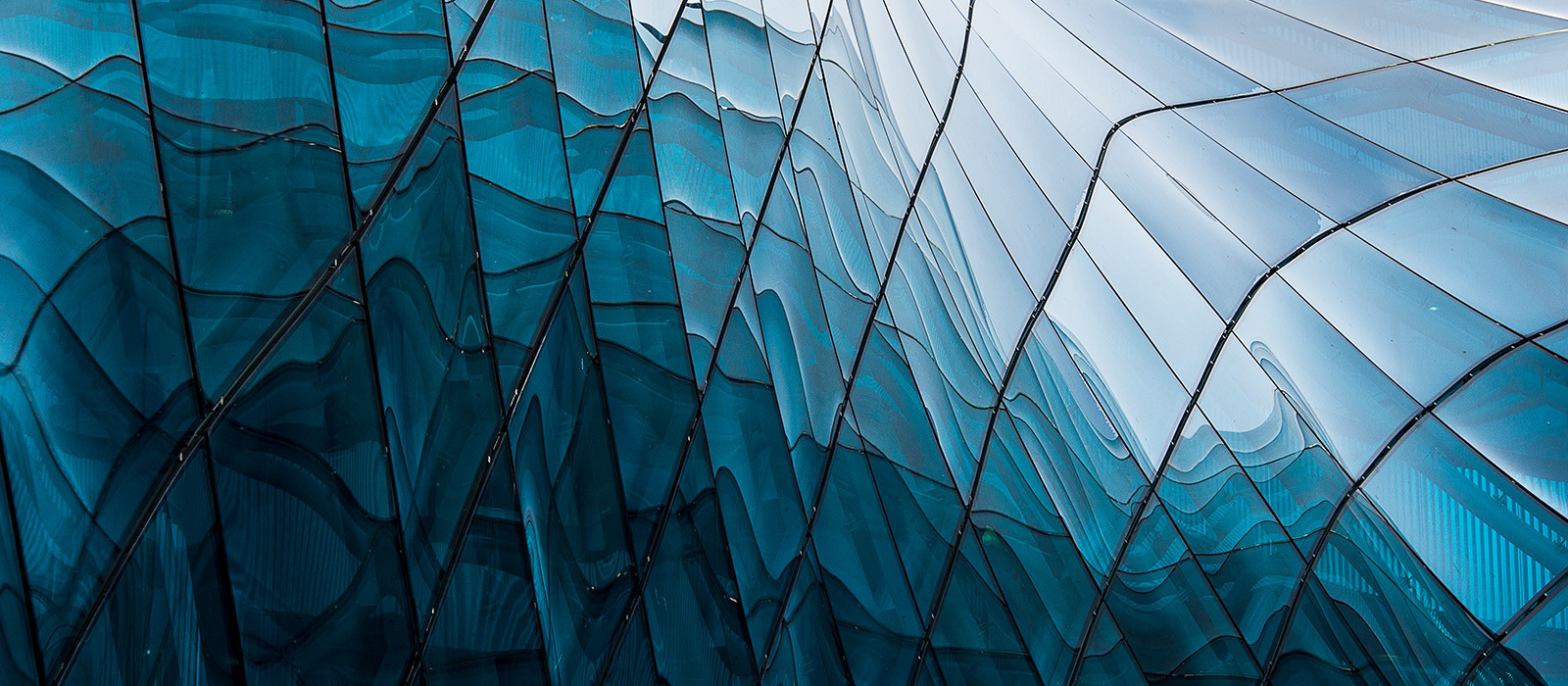 Abstract wall of rectangular glass panels that arch upward