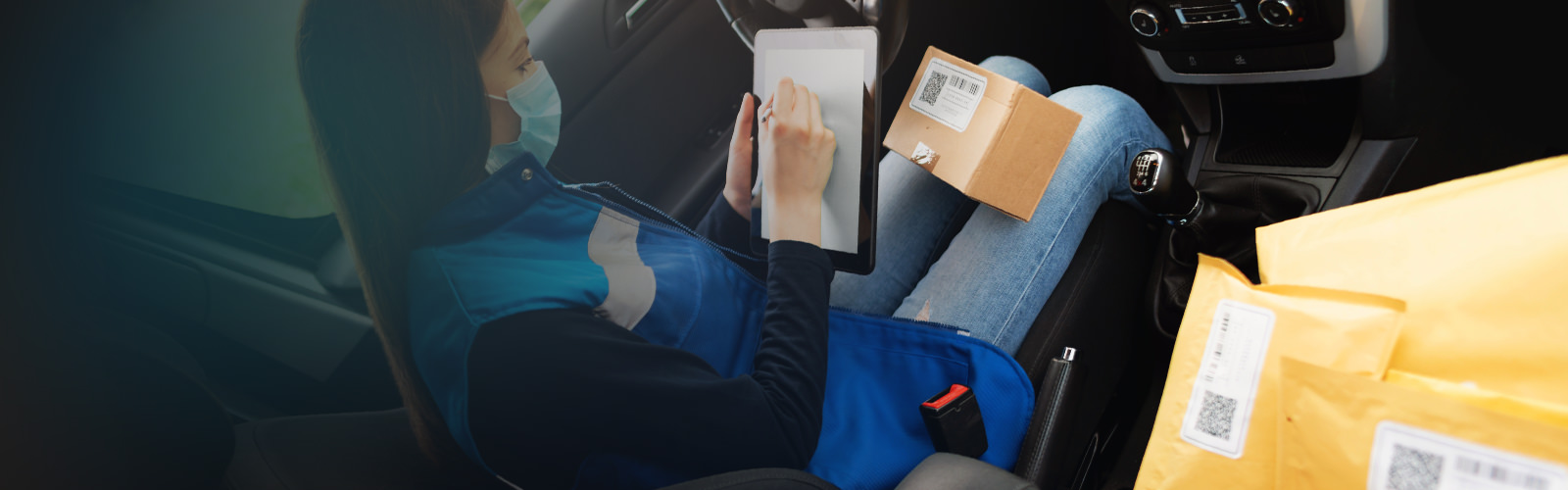 Woman using a tablet with packages nearby.