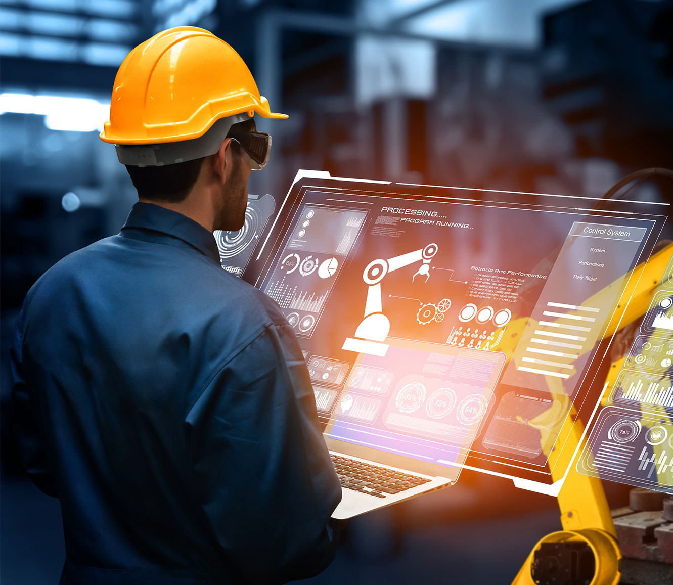 Man looking at  a monitor which has robot arms